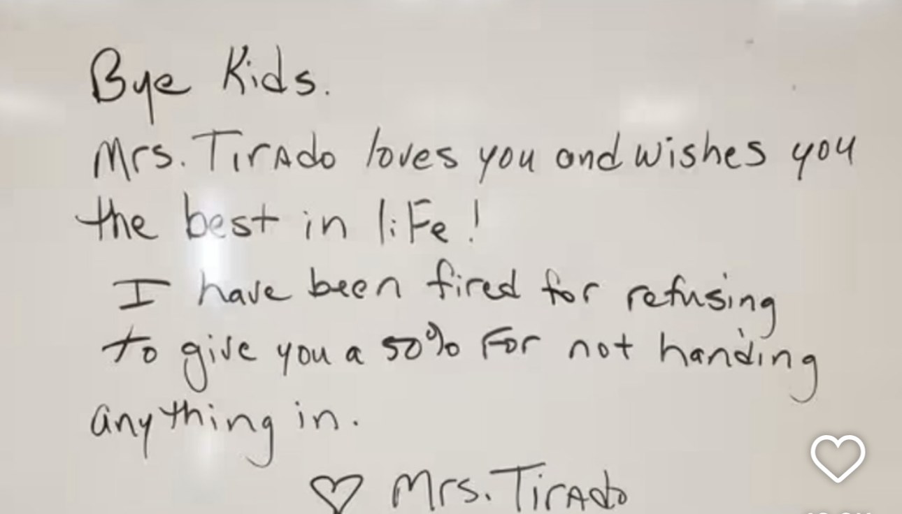 Photograph of a classroom whiteboard with a handwritten message. It reads: Bye Kids. Mrs. Tirado loves you and wishes you the best in life! I have been fired for refusing to give you a 50% for not handing anything in. It is signed with a heart, Mrs. Tirado.